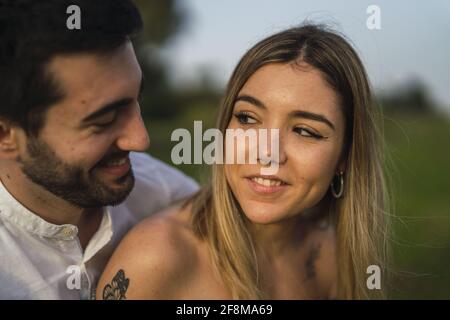 Ritratto di una giovane coppia che si agganava e sorridente Foto Stock