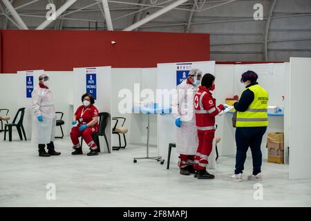 Catanzaro, Calabria, Italia. 12 Aprile 2021. Un membro della protezione civile italiana si prepara alla vaccinazione durante l'inaugurazione.è stato inaugurato l'hub vaccino COVID-19, istituito presso il Centro Fieristico di Catanzaro Lido, considerato il più grande della regione, potenzialmente può avere la capacità di effettuare 2,500 vaccinazioni al giorno. Diverse autorità regionali e locali hanno partecipato all'evento e il personale di organizzazioni caritative ha ricevuto il vaccino AstraZeneca. Credit: Valeria Ferraro/SOPA Images/ZUMA Wire/Alamy Live News Foto Stock