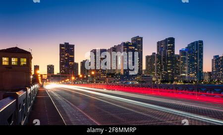 Skyline della città di Miami con percorsi a semaforo in movimento di notte sul Venetian Causeway, Florida, USA Foto Stock