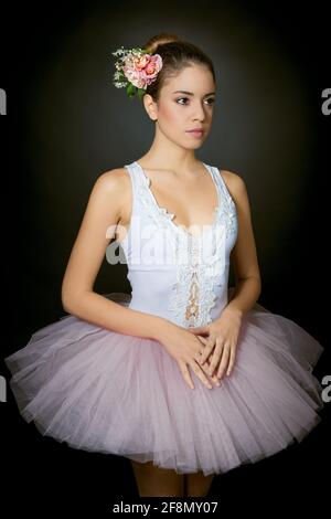 Ballerina giovane con trucco leggero e capelli legati decorati con fiori su  sfondo scuro Foto stock - Alamy