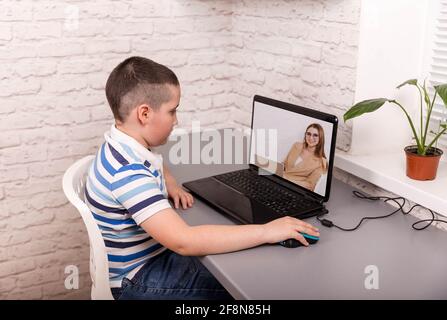 Formazione online a distanza. Un ragazzo studia a casa Foto Stock