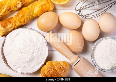 Vista dall'alto di croissant e altri dolci con ingredienti un tavolo di legno in cucina Foto Stock