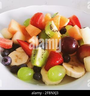 Macedonia di frutta fresca come concetto di alimentazione sana e dieta naturale, frutta organica mista in una ciotola Foto Stock