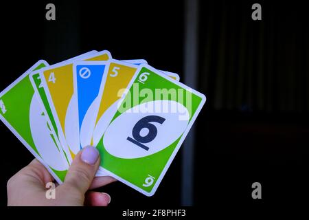 Kiev, Ucraina - 10.03.2021 carte da gioco uno in mano femminile. Giochi da tavolo. Passatempo. Giochi da tavolo. Soggiorno casa attività di svago per i bambini. Pandemia Foto Stock