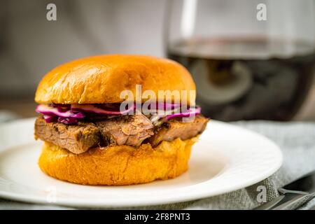 Brisket Slider Sandwich Bun on White Plate cena vino rosso Pranzo Appetizer pasto barbecue barbecue Texas barbecue barbecue barbecue barbecue barbecue Barbeque Foto Stock