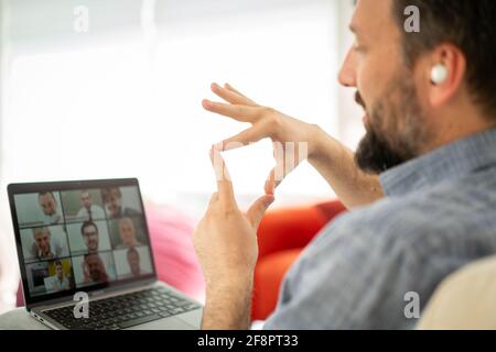 Uomo medio adulto che ha una conferenza online che lavora a casa Foto Stock