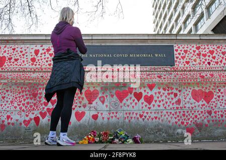 La gente cammina oltre e scrive sul muro commemorativo nazionale del Covid, a Londra il 9 aprile 2021 Foto Stock