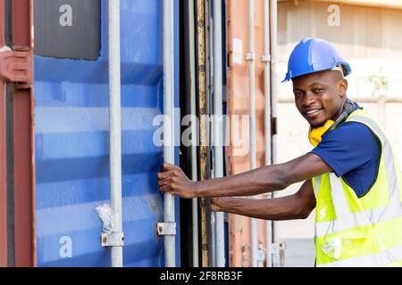 I lavoratori neri afroamericani stanno aprendo contenitori per l'ispezione e il controllo che le riparazioni siano state completate in contenitori Foto Stock