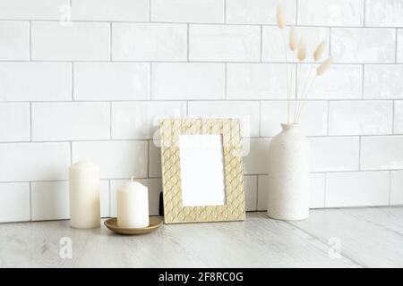 Mockup cornice d'oro e arredamento di casa sul tavolo all'interno del soggiorno. Scandinavo, stile nordico. Foto Stock
