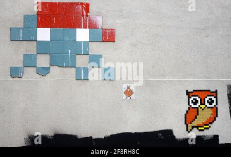 Londra, Inghilterra, Regno Unito. Arte a mosaico in West Central Street, fuori Oxford Street. Space Invader e un gufo Foto Stock