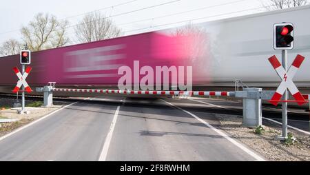 Sorsum, Germania. 15 Aprile 2021. Un treno merci passa attraverso un passaggio in piano. In occasione della Conferenza dei Ministri dei Trasporti (VMK), gli stati federali discutono della rapida espansione del trasporto ferroviario con il governo federale. Credit: Julian Stratenschulte/dpa/Alamy Live News Foto Stock