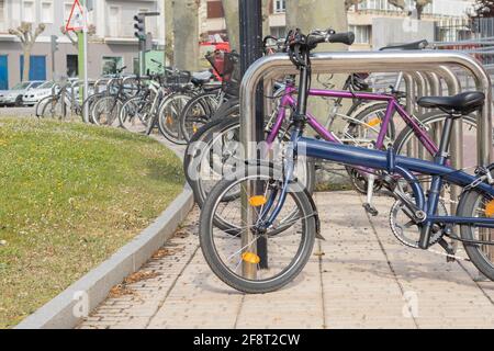 Biciclette di diversi colori e forme parcheggiate in un parcheggio lotto o luogo per tenerli nel mezzo di la città con il concetto di mobilità urbana wit Foto Stock