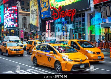 Questo negozio Disney si trova a Manhattan in Times Square nel cuore della Grande Mela. Taxi sulla trafficata Broadway di fronte al negozio New York Manhatt Foto Stock