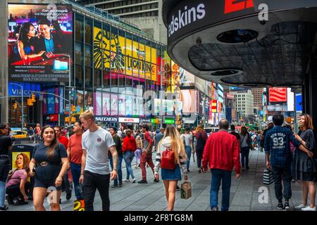 I visitatori e i turisti si divertono nella affollata Times Square, 42nd Street a Manhattan, New York City. Foto Stock