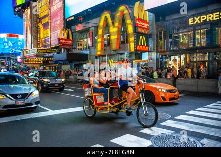 McDonald's fast foot Restaurant situato a Manhattan in Times Square nel cuore della Grande Mela. Pedicabs taxi sulla trafficata Broadway di fronte alla st Foto Stock