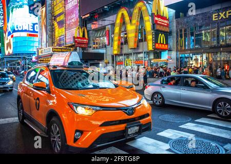 McDonald's fast foot Restaurant situato a Manhattan in Times Square nel cuore della Grande Mela. Taxi sulla trafficata Broadway di fronte al negozio New Y Foto Stock