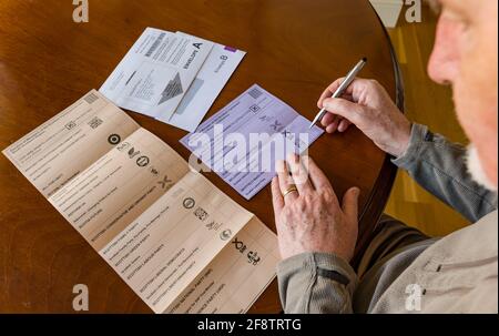 East Lothian, Scozia, Regno Unito, 15 aprile 2021. I voti postali arrivano per le elezioni scozzesi: I residenti della contea possono votare per l'MSP della Lotia orientale e la regione del sud della Scozia. I candidati per il primo sono Euan Davidson (liberali democratici scozzesi), Craig Hoy (conservatori scozzesi e unionisti), Paul McLennan (SNP) e Martin Whitfield (laburisti scozzesi ed ex deputato che ha perso nel 2019 a Kenny MacAskill che sta per Alba). La Lista Regionale comprende 16 parti. Un uomo considera chi votare per il voto sulla scheda elettorale Foto Stock