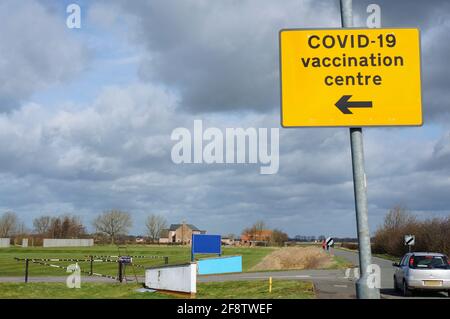 Cartello di direzione per il centro di vaccinazione COVID 19 e diversi cartelli sbozzati. Foto Stock