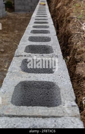 Immagine verticale di una fila di blocchi cavi sul terreno per lavori edili Foto Stock