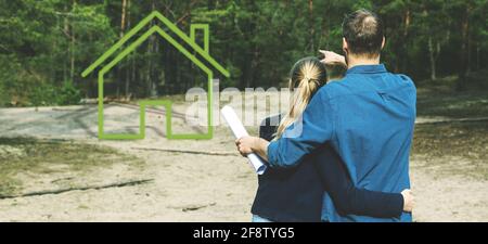 giovane coppia in cerca di terreno e sognare piccolo lodge nella foresta Foto Stock