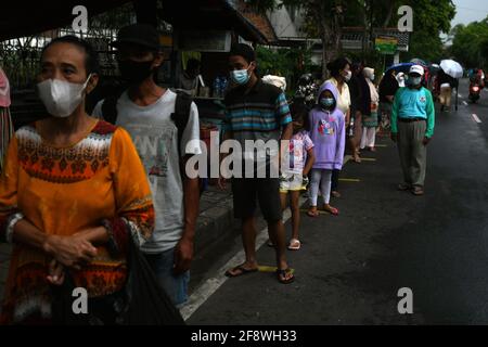 Giacarta, Giacarta, Indonesia. 14 Apr 2021. I residenti si accodano per ottenere il fast food gratuito (takjil) su Cempaka Putih Tengah Street, Jakarta, il 15 aprile 2020. La distribuzione di cibo veloce gratuito (takjil) residenti forl è effettuata implementando rigorosi protocolli di salute con una varietà di alimenti speciali per rompere il veloce Ramadan Credit: Dasril Roszandi/ZUMA Wire/Alamy Live News Foto Stock