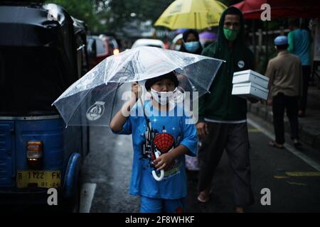 Giacarta, DKI Jakarta, Indonesia. 15 Aprile 2021. I residenti si accodano applicando la regola della distanza per ottenere il takjil libero sulle strade del centro di Giacarta, giovedì (04/15/2021). I residenti sono obbligati ad accodarsi applicando una distanza di due metri per prevenire la diffusione del coronavirus. Eeveryday la commissione fornisce 400-600 pacchetti takjil gratuitamente che sono donazioni da residenti e società nella regione. Credit: Muhammad Zaenuddin/ZUMA Wire/Alamy Live News Foto Stock