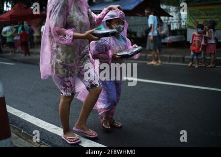 Giacarta, DKI Jakarta, Indonesia. 15 Aprile 2021. I residenti si accodano applicando la regola della distanza per ottenere il takjil libero sulle strade del centro di Giacarta, giovedì (04/15/2021). I residenti sono obbligati ad accodarsi applicando una distanza di due metri per prevenire la diffusione del coronavirus. Eeveryday la commissione fornisce 400-600 pacchetti takjil gratuitamente che sono donazioni da residenti e società nella regione. Credit: Muhammad Zaenuddin/ZUMA Wire/Alamy Live News Foto Stock