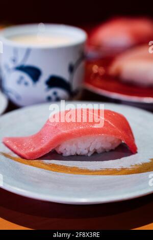 Sushi e Sashimi. Piatti di Sushi e Sashimi rotolando su nastro trasportatore. Foto Stock