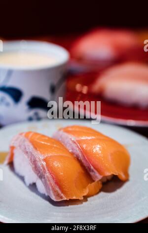 Sushi e Sashimi. Piatti di Sushi e Sashimi rotolando su nastro trasportatore. Foto Stock