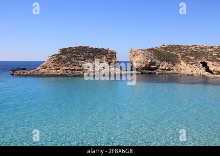 La vista della baia di Blue Lagoon con acqua pulita di cristal catturata dalla spiaggia locale. Conimo, Malta. Foto Stock