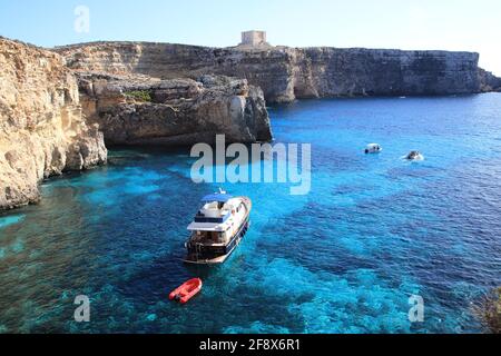 Isola di Comino, Malta - 20 ottobre 2020: Barche con turisti, vista dalla roccia sulla laguna di Cristal. Foto Stock