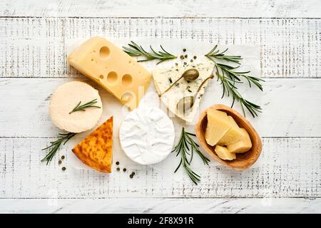 Formaggi assortiti o assortiti. Suluguni con spezie, camembert, formaggio blu, parmigiano, maasdam, brie con rosmarino e pepe. Vista dall'alto. Su bianco WO Foto Stock