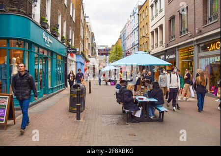 Londra, Regno Unito. 14 aprile 2021. Una trafficata Carnaby Street nel centro di Londra. Negozi, ristoranti, bar e altre aziende riaprirono dopo quasi quattro mesi, mentre in Inghilterra si rilassano le regole di blocco. Foto Stock