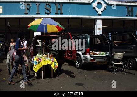 St George's Grenada gente del posto che vende frutta e verdura fuori La parte posteriore delle automobili fuori del mercato del pesce Foto Stock