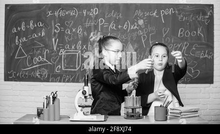 Alla ricerca di una soluzione medica adeguata. Lo scienziato piccolo lavora con il microscopio. Bambine in laboratorio. Educazione chimica. Esperimenti scientifici in chimica Foto Stock