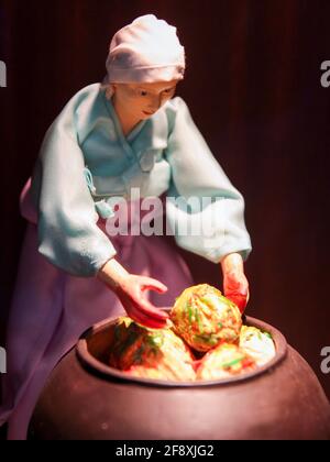 Diorama di una donna che carica cavolo, verdure in una pentola di argilla per kimchi. Al Kimchi Field Museum di Seoul, Corea del Sud. Foto Stock