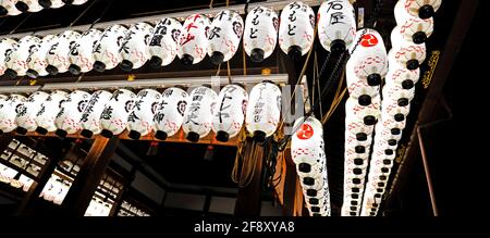 Vista di molte lanterne giapponesi appese di notte, quartiere di Gion, Kyoto, Giappone Foto Stock