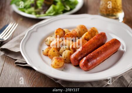 Salsicce e patate su un piatto. Foto di alta qualità. Foto Stock