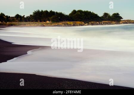 Lunga esposizione di onde di mare che si affacciano sulla spiaggia di sabbia, Fort Bragg, California, USA Foto Stock