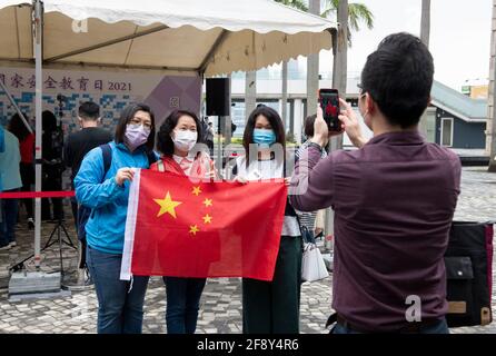 HONG KONG, HONG KONG SAR, CINA: 15 APRILE 2019. I cittadini patriottici (alcuni in posa aperta con la Bandiera Cinese) approfittano di alcuni degli eventi che celebrano la prima Giornata Nazionale dell'Educazione sulla sicurezza presso il Centro Culturale Promenade Tsim Sha Tsui, Hong Kong. Con l'obiettivo di celebrare l'introduzione delle leggi sulla sicurezza nazionale a Hong Kong alle 23.00 del 30 giugno 2020, questa celebrazione annuale si terrà ogni anno il 15 aprile. La gente ha le foto di se stessa stampate e attaccate ad un bordo che genera un'immagine ed uno slogan pro NSL. Alamy Live News/Jayne Russell Foto Stock