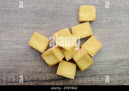 tofu fritto vegetariano isolato su tavolo di legno Foto Stock