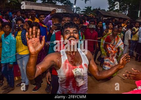 Hooghly, India. 14 Apr 2021. (L'immagine della nota dei redattori contiene grafici) UN devoto perfora la sua lingua da un'asta di spiedo durante il festival. Gajan è un festival indù celebrato soprattutto nel Bengala occidentale e nella parte meridionale del Bangladesh. Il festival è associato alla devozione su lord Shiva, e continua nel corso di una settimana nell'ultimo mese dell'anno bengalese. I popoli celebrano Gajan eseguendo molti rituali e coloro che eseguono questi rituali sono chiamati Sannyasi o devoti. Credit: SOPA Images Limited/Alamy Live News Foto Stock