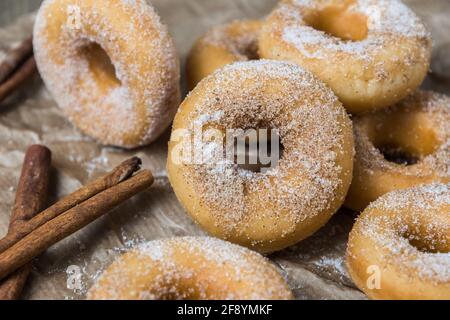 Closeup di mini ciambelle con zucchero e cannella su a. carta marrone Foto Stock
