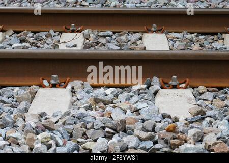 primo piano di rotaie arrugginite su ghiaia Foto Stock