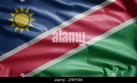 Bandiera della Namibia sventolando nel vento. Primo piano di Namibia banner soffia, seta morbida e liscia. Tessuto tessuto tessuto tessitura segno sfondo. Foto Stock