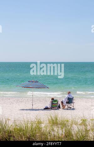 Coppia rilassante alla spiaggia lungo il Golfo del Messico, Napoli, Florida, Stati Uniti Foto Stock