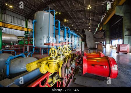 Aksu, regione Pavlodar, Kazakhstan - 29 maggio 2012: Officina della centrale a vapore Aksu. Coni rossi del sistema estintore. Serbatoi grigi con tubi blu. Foto Stock