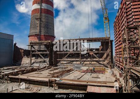 Stazione a vapore GRES-1. Vista panoramica sulla demolizione di vecchi bunker di carbone grezzo. Cantiere e ristrutturazione di impianti. Pila di fumo sinistra. Foto Stock