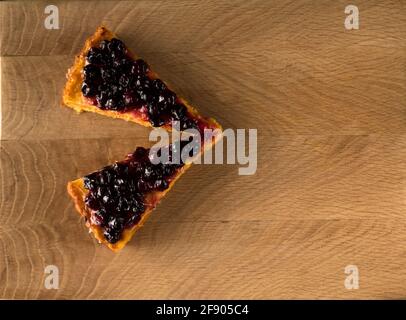 Due fette di torta di carote, spessamente ricoperte con ribes sopra, charlotte, su una tavola di legno Foto Stock