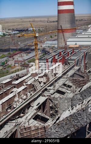 Centrale termica GRES-1. Modernizzazione e demolizione di edifici industriali obsoleti. Pila di fumo, steppa secca, cielo blu. Ekibastuz, KZ. Foto Stock